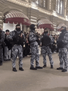 a group of soldiers are standing in front of a building with cnn written on the awning