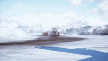 a car is driving on a snowy road with a mountain in the background