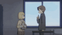 a boy and a girl are standing in front of a window and the girl is holding a soccer ball with the letter s on it
