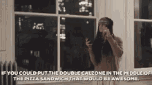 a woman is taking a picture of a pizza sandwich in front of a window ..