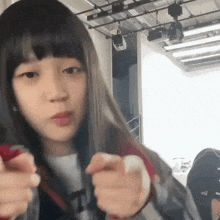 a young girl with long black hair is holding a pair of scissors .