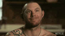a shirtless man with a tattoo on his shoulder is smiling in a netflix ad
