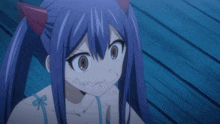 a girl with blue hair and red horns is looking at the camera