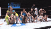 a group of women wrestling in a ring with a sign that says station on it