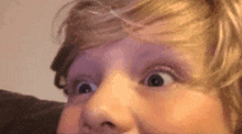 a close up of a person 's face with their eyes wide open and a surprised look on their face .