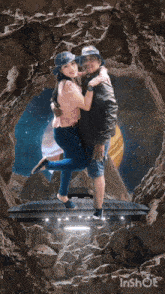 a man is holding a woman in his arms in front of a planet in a cave