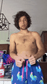 a shirtless man is standing in front of a ketchup bottle that says ' heinz ' on it