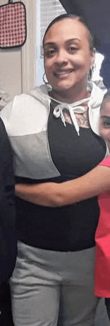 a woman is hugging a little girl in a room .