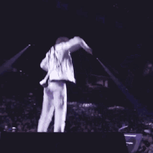 a man is jumping in the air on a stage while dancing .