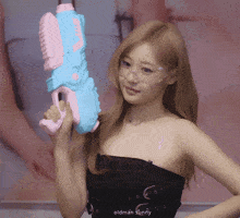 a woman is holding a pink and blue water gun with the words oldman sunny below her