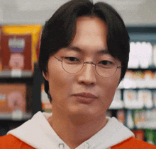 a close up of a man wearing glasses and a white sweatshirt
