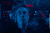 a man with his eyes closed is standing in a dark room
