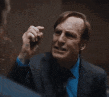 two men in suits are standing next to each other in a hallway .