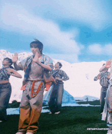 a group of people are dancing in a field with the words jintianyeziaoyikou at the bottom