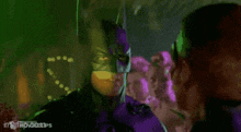 a remote raid pass for batman is being held by a person