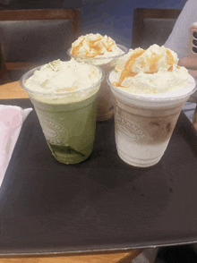 three cups of coffee on a tray that say milanos