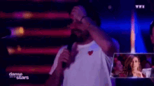 a man is holding a microphone in front of a tfi logo
