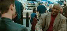 a man in a suit is smiling while sitting at a table with another man
