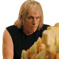 a man with blonde hair and a black tank top is looking at something