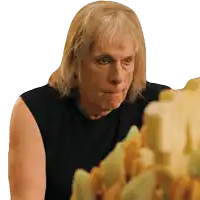 a man with blonde hair and a black tank top is looking at something