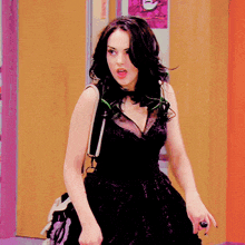 a woman in a black dress stands in front of a door with a picture of a monkey on it