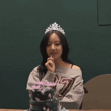 a woman wearing a crown and a sweater with the number 27 on it