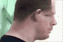 a close up of a man 's face with a green background