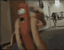a 4gifs.com image of a hot dog being held by a person