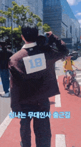 a man with the number 18 on his back is walking down the street