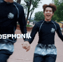 two young men holding hands with the word osphone in white letters