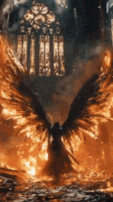 a man with wings is standing in front of a burning church .