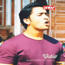 a man wearing a purple shirt that says vidio