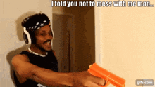 a man wearing headphones is holding a gun and says " i told you not to mess with me man ... "