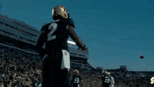a football player is running on the field with a football in his hands .