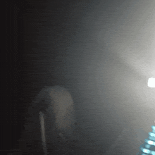 a blurred image of a person standing in a dark room