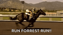 a jockey is riding a horse on a race track with the words `` run forrest run '' behind him .
