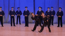 a group of men in sailor uniforms are dancing on stage