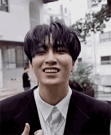 a close up of a person wearing a suit and smiling .