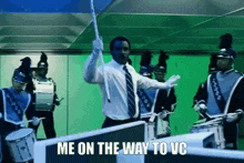 a man in a suit and tie is standing in front of a marching band with the words me on the way to vc below him