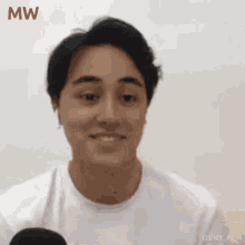 a close up of a man 's face with the word mw in red
