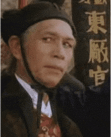a man in a suit and tie stands at a podium with chinese writing on it
