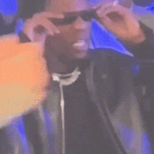 a man wearing sunglasses and a suit is taking a picture of himself .
