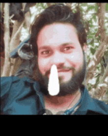 a man with a beard is holding a piece of paper to his nose