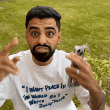 a man with a beard is wearing a shirt that says " i want peace in the world so i write jolly tales "