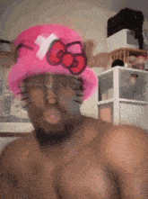 a shirtless man wearing a hello kitty hat
