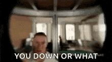 a man is standing in front of a window and says `` you down or what '' .