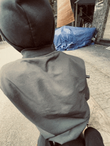 a person wearing a hooded jacket is walking down a street