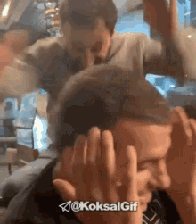 a gif of a man covering his face with his hands with the hashtag @koksalgif