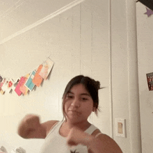 a woman is dancing in a room with a white wall .