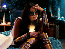 a woman sitting on a bed wearing sunglasses and armor